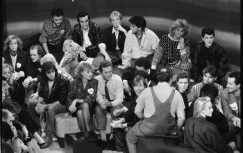 De nombreuses personnalités participent à l'émission télévisée de TF1 pour les Restaurants du Cœur organisée par son fondateur Coluche (de dos), à Paris le 26 janvier 1986 © Michel Gangne / AFP